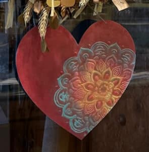 Finished heart painting hanging on door