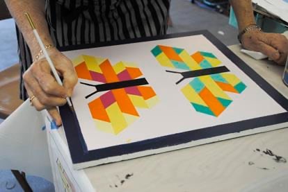 Volunteer painting a quilt block